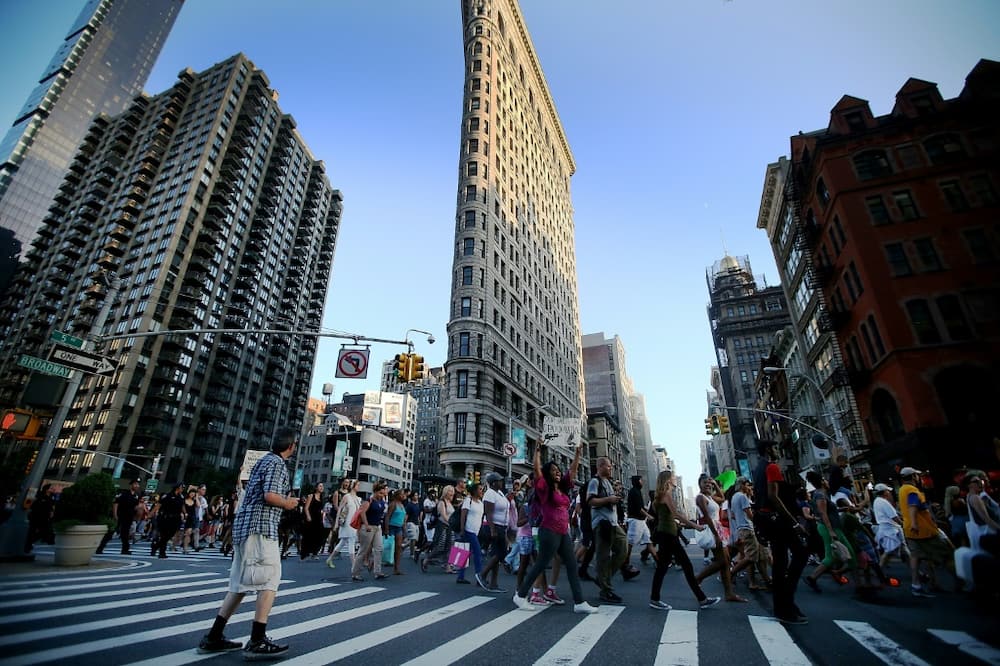 People march past the iconic Flatiron Building in New York