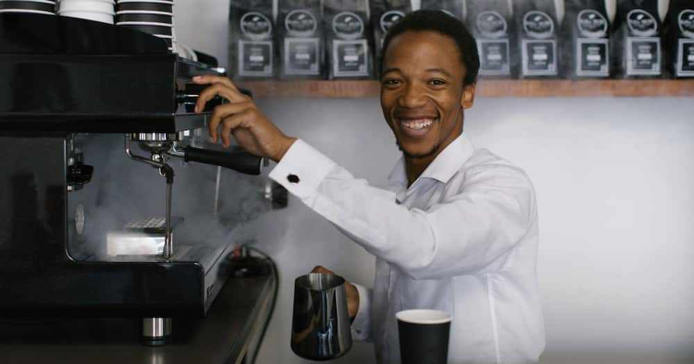 Mhlengi Ngcobo working a coffee machine at his shop
