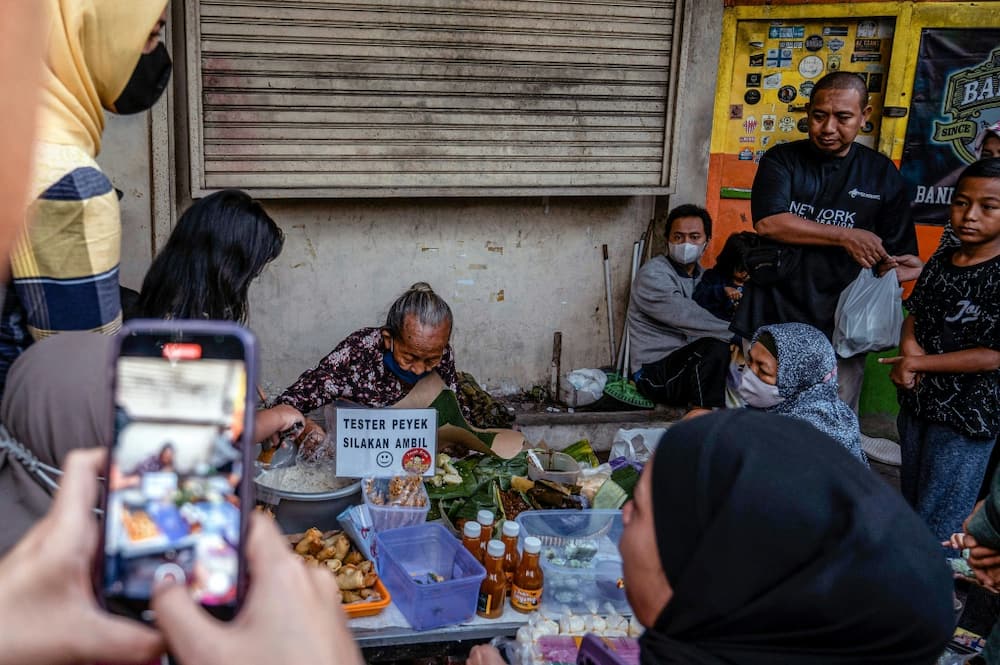 Customers at 76-year-old Mbah Satinem's stall often use their smartphones to capture her at work