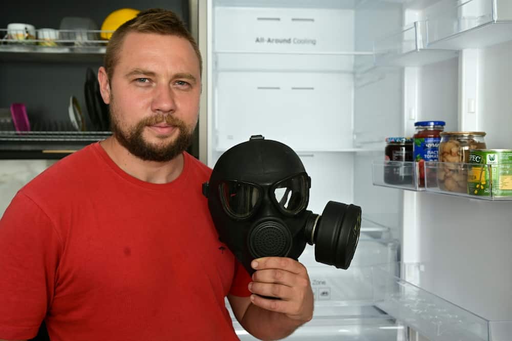 Yevgen with the gas mask he uses for cleaning out fridges