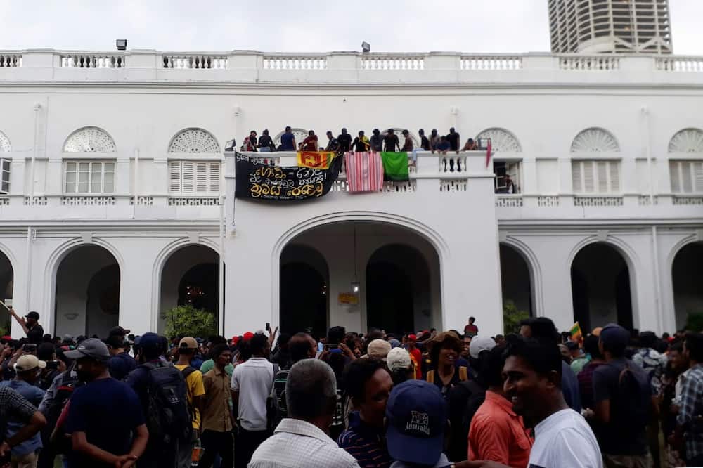 Protesters are seen on the balcony of the presidential palace on Saturday