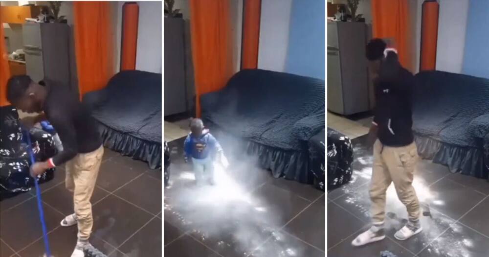 Man sweeping floor is disrupted by his kid.
