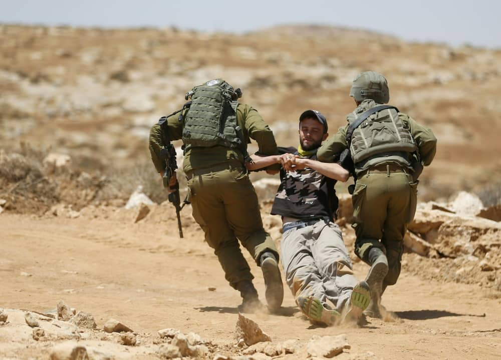 Israeli forces remove a demonstrator during a protest by Palestinians and international activists in the Masafer Yatta area of the Israeli-occupied West Bank on July 1, 2022