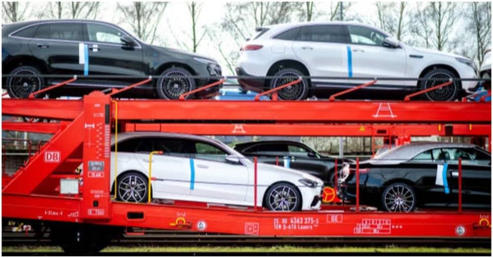Several new Mercedes-Benz cars stand on a rail wagon.